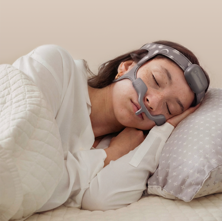 Woman sleeping on her side while wearing the Dormovision X™ Head Unit